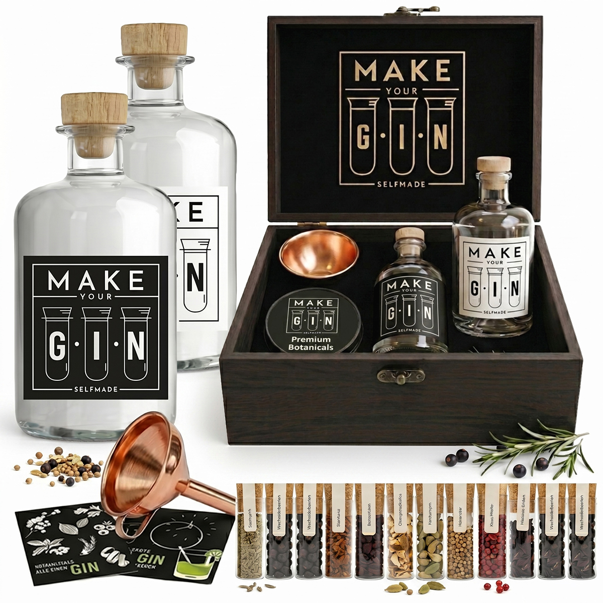 Geöffnete dunkle Holzbox des Make Your Gin DIY-Sets mit zwei großen Glasflaschen, Kupfertrichter, Rezeptkarten und einer Auswahl an Botanicals in Reagenzgläsern auf weißem Hintergrund.